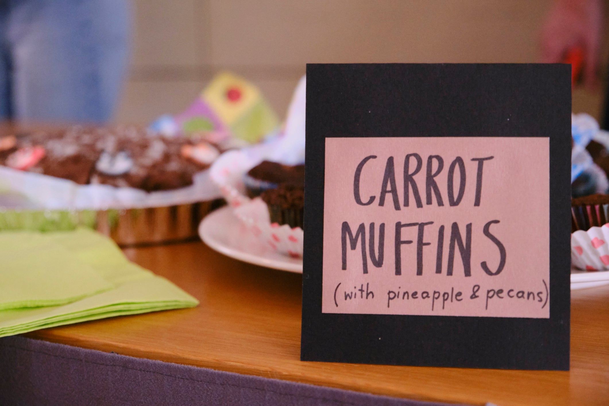 carrot muffins sign on a school bake sale table