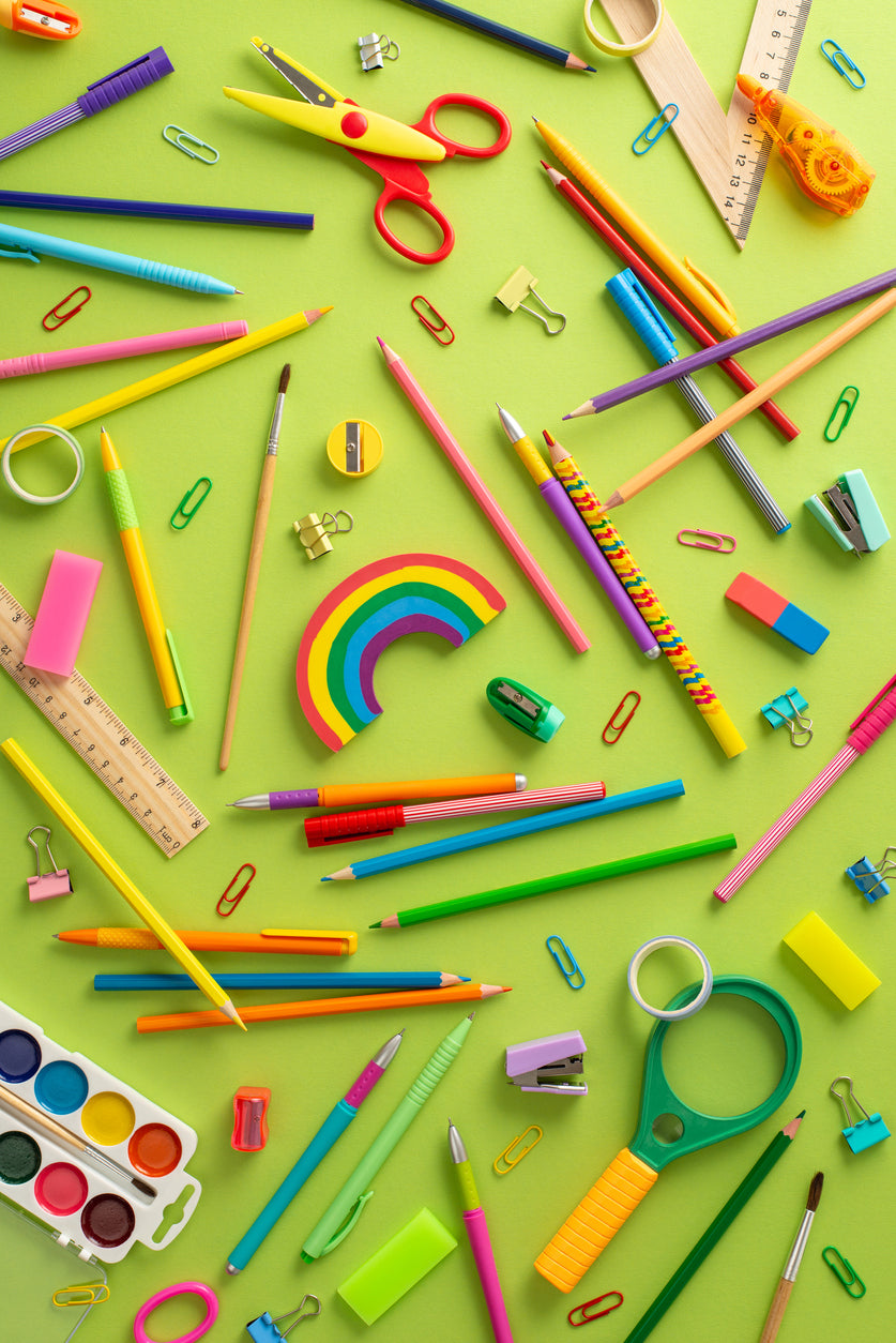 bright colored school supplies spread out on a bright green background