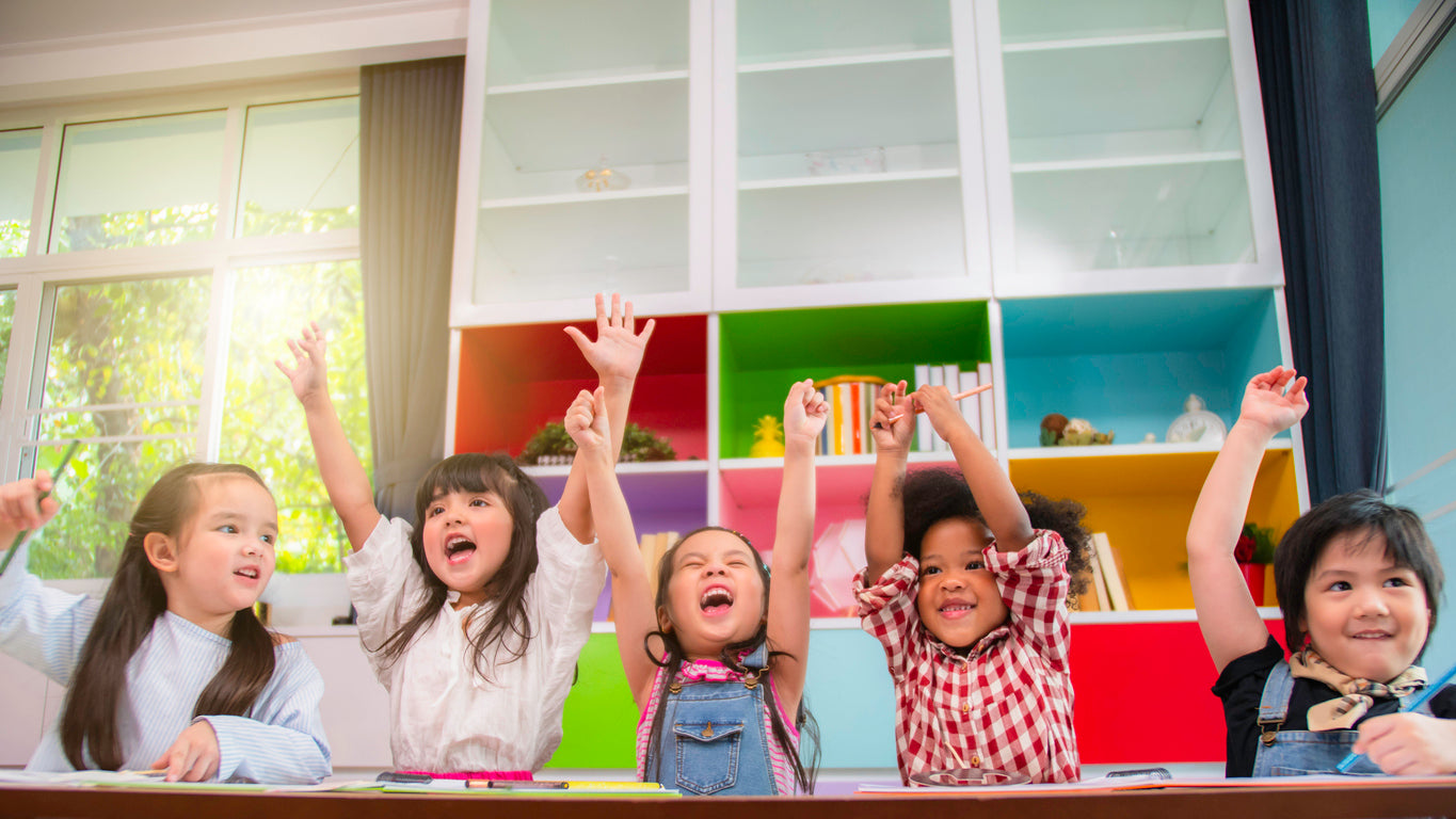 elementary students having fun in bright colored classroom