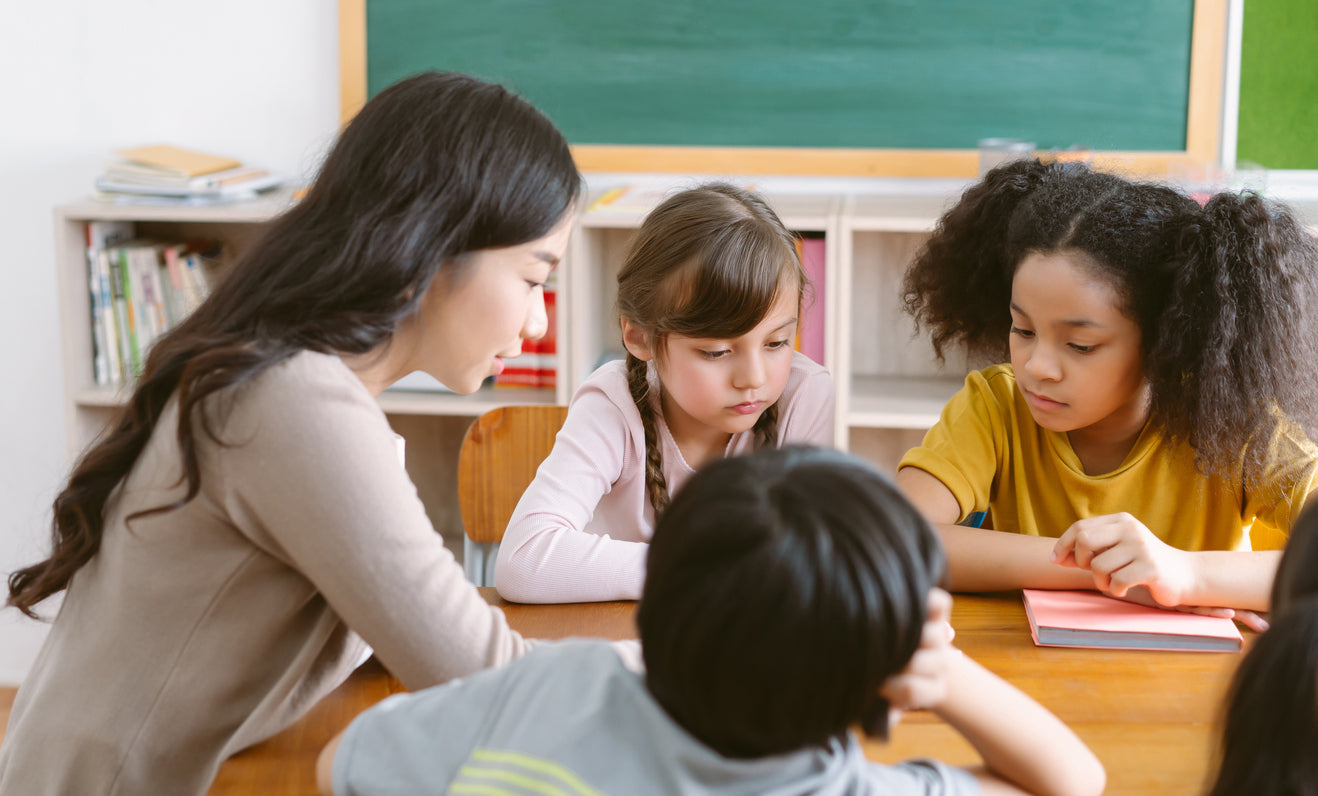 students reading at a table in the classroom